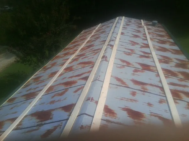 Rusted metal roof panels with new wood purlins before replacement — Storm Damage Roof Repair in West Leyden by Roofing Brothers