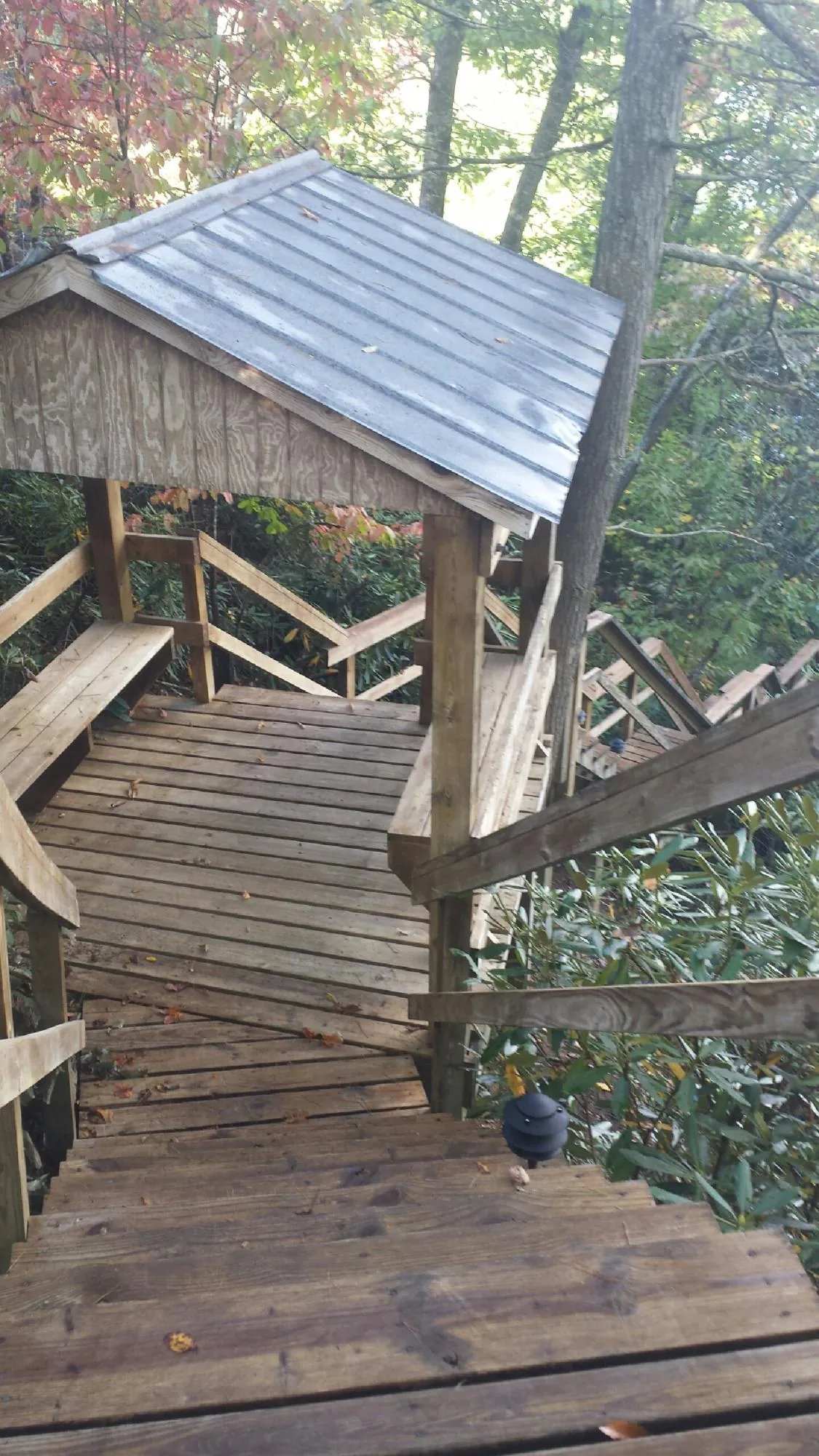 Metal roofed shelter over wooden steps on a wooded walkway — Skylight Repair & Installation work by our crew in West Leyden