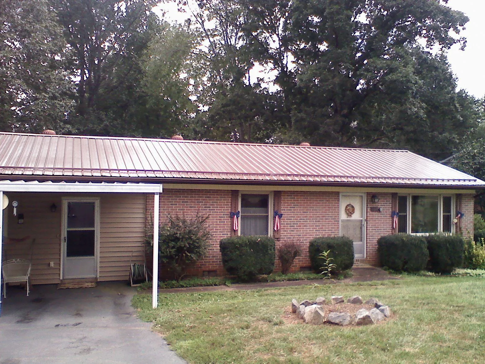 Bronze metal roof and carport on a brick ranch home — Roof Repair work by our crew in West Leyden
